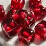 Pomegranate Caramels: A Sweet & Tangy Treat You’ll LoveIntroduction 11 Stacked glossy pomegranate caramels on a white plate